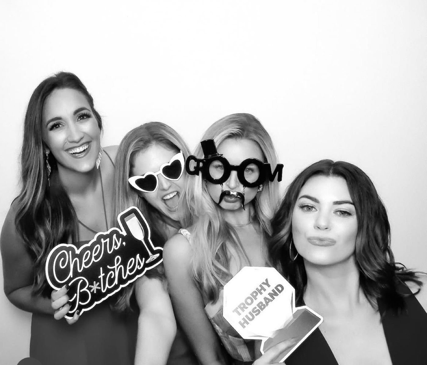 Guests posing together in a black and white photobooth portrait