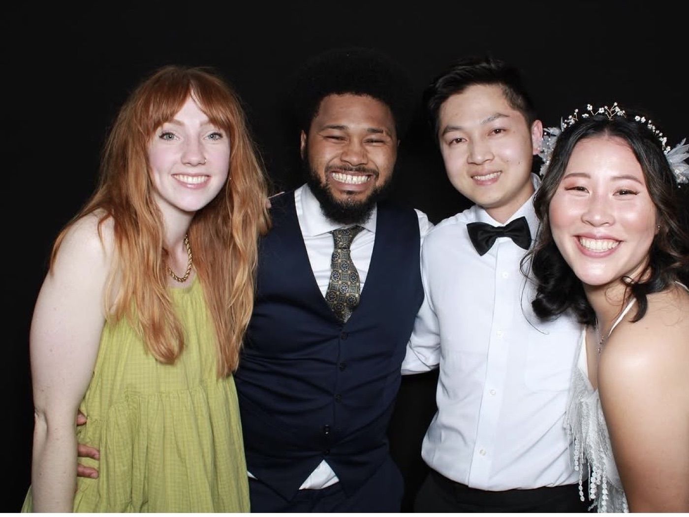 Group of friends smiling together in an open-air photobooth