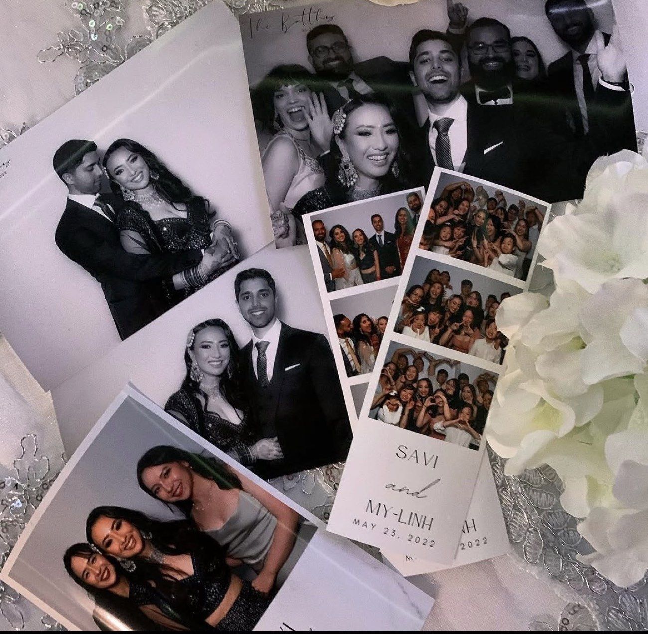 Printed photobooth strips styled in a flatlay with florals