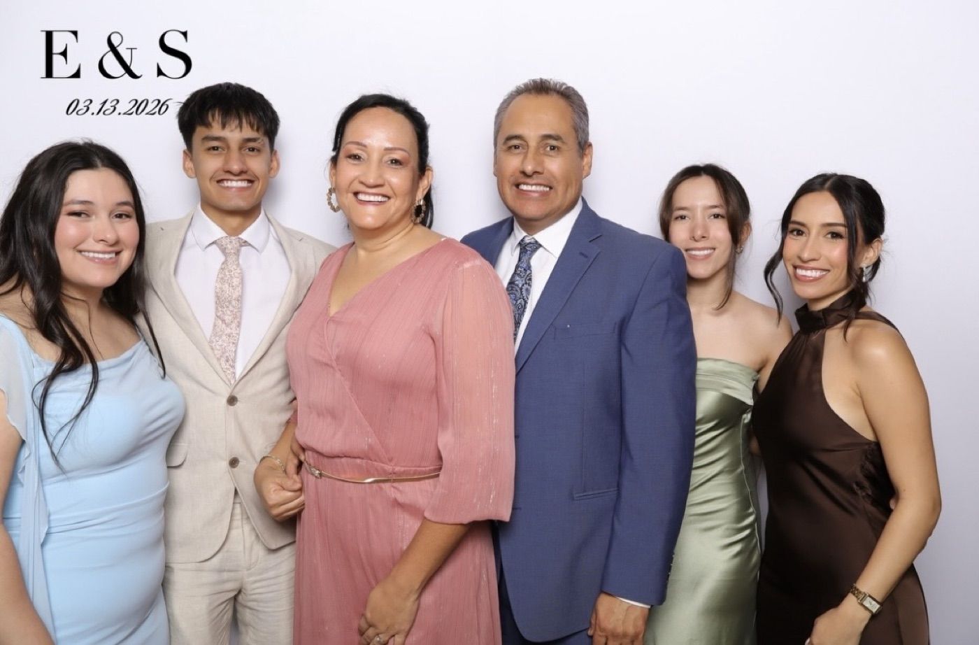 Family posing together at a wedding photobooth