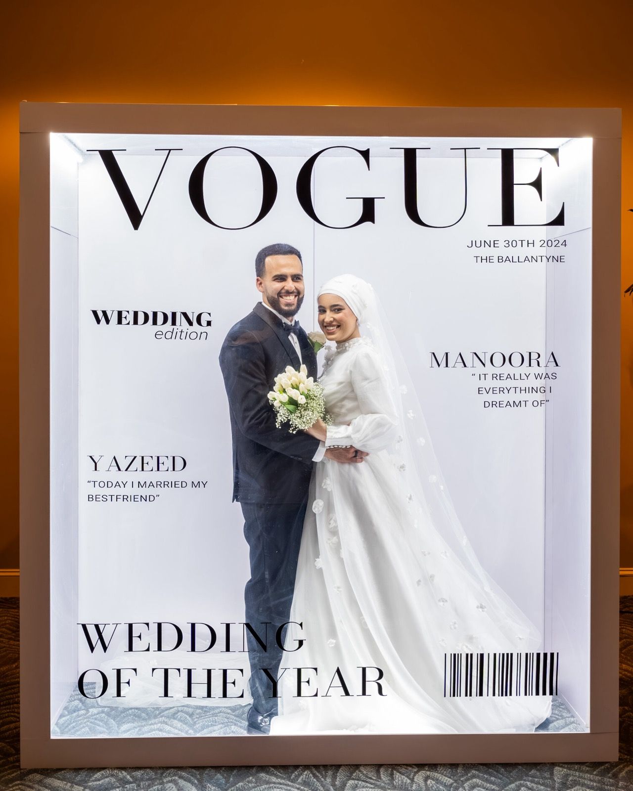 Guests posing inside an illuminated magazine cover photobooth